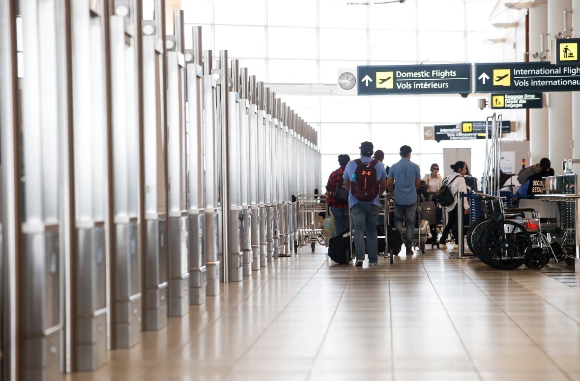 Passengers and signage at Winnipeg airport.