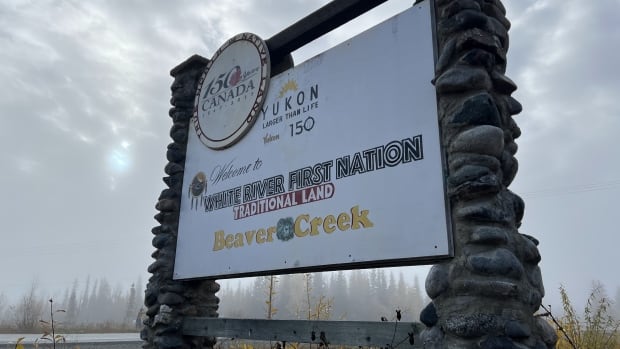 A large sign beside a road welcomes people to White River First Nation traditional land. 