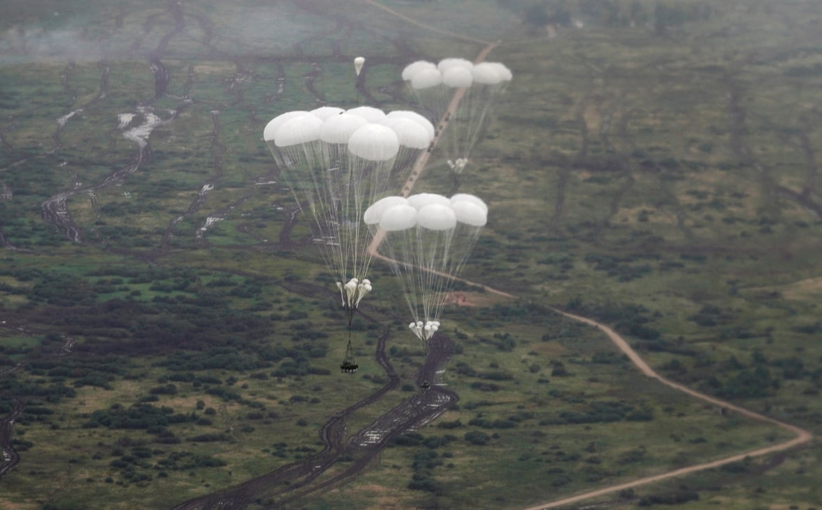 In the picture taken from the nearest plane, few parachites are shown above the mass of the world.