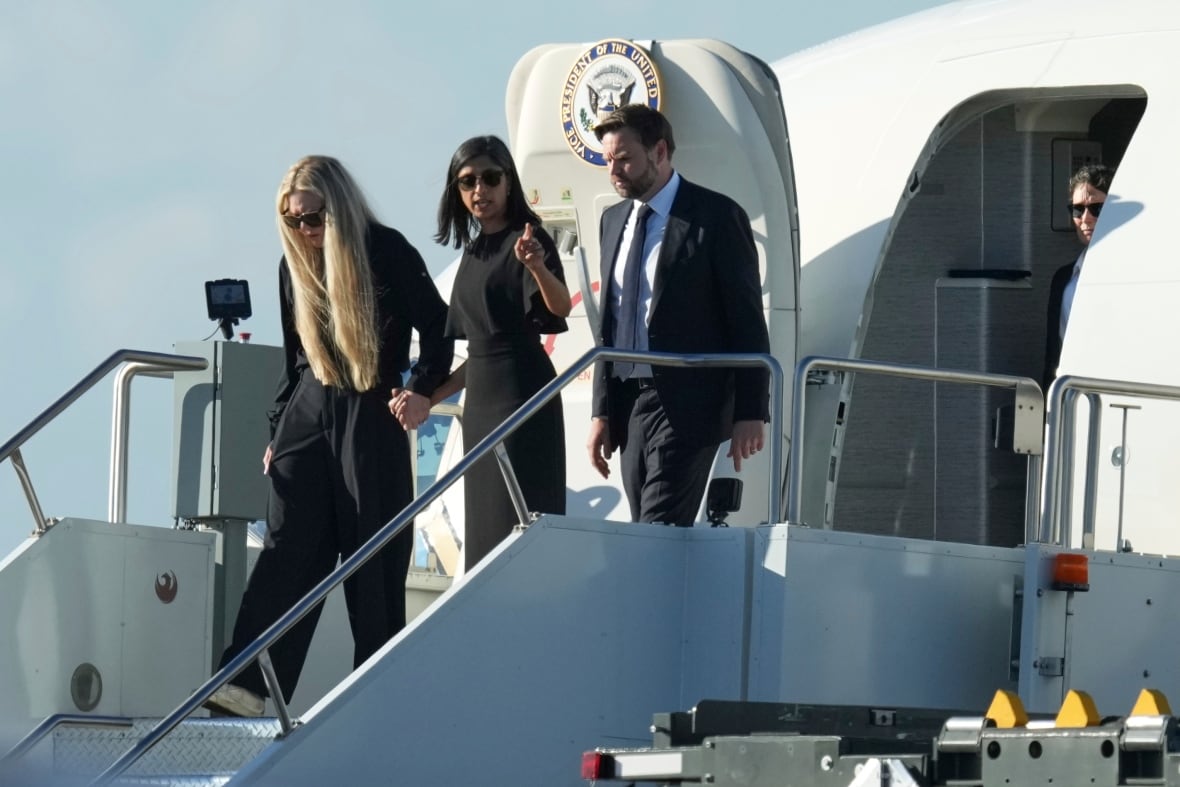 Two women and two men from a plane with a sign of the door saying: Vice President of the United States.