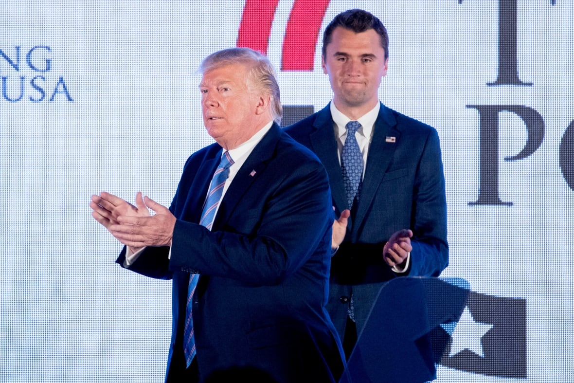 Two Cleanshaven men wear a suit and tie during the stage on the stage. One of them is smaller than brown hair, while the person in the front is a big citizen, with blond hair.