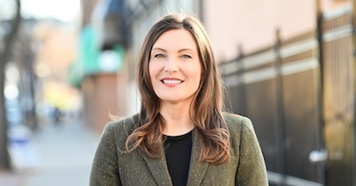 A person stands on a sidewalk.