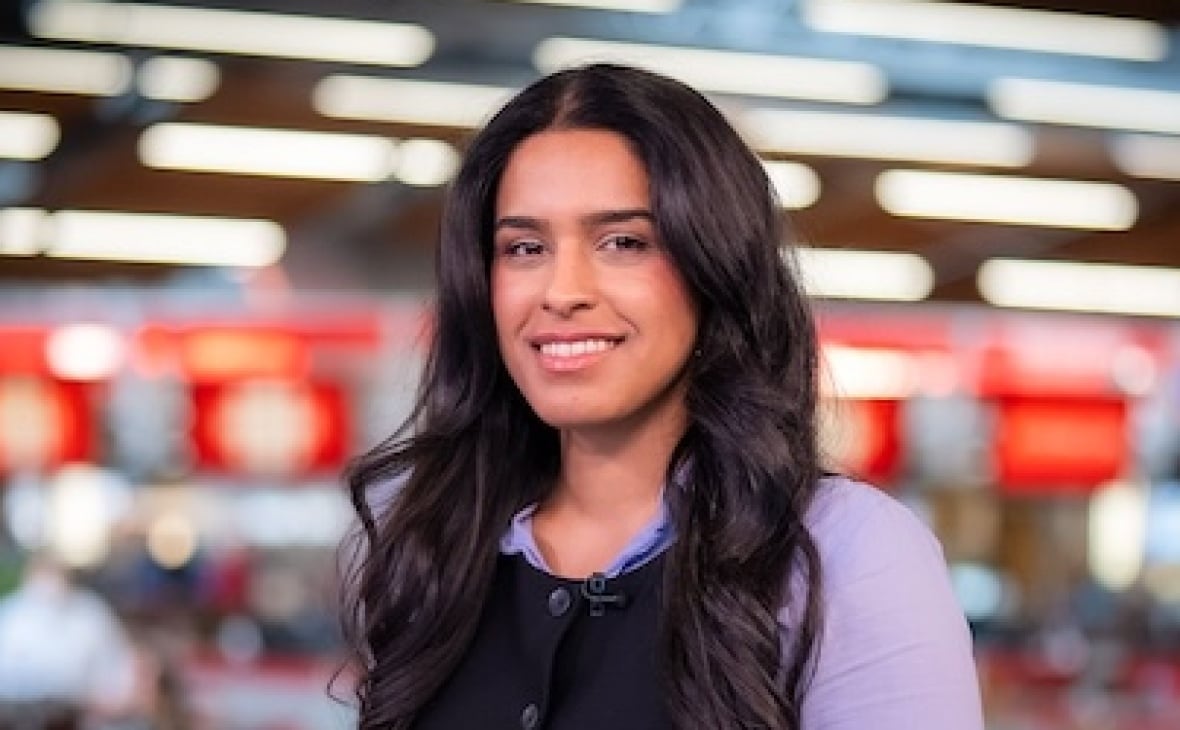 A person stands in a newsroom.