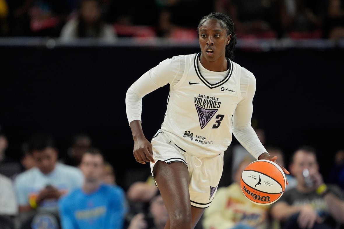 A women's basketball player is shown dribbling the ball.