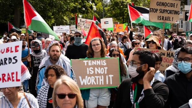 Hundreds of demonstrators block a street while protesting.