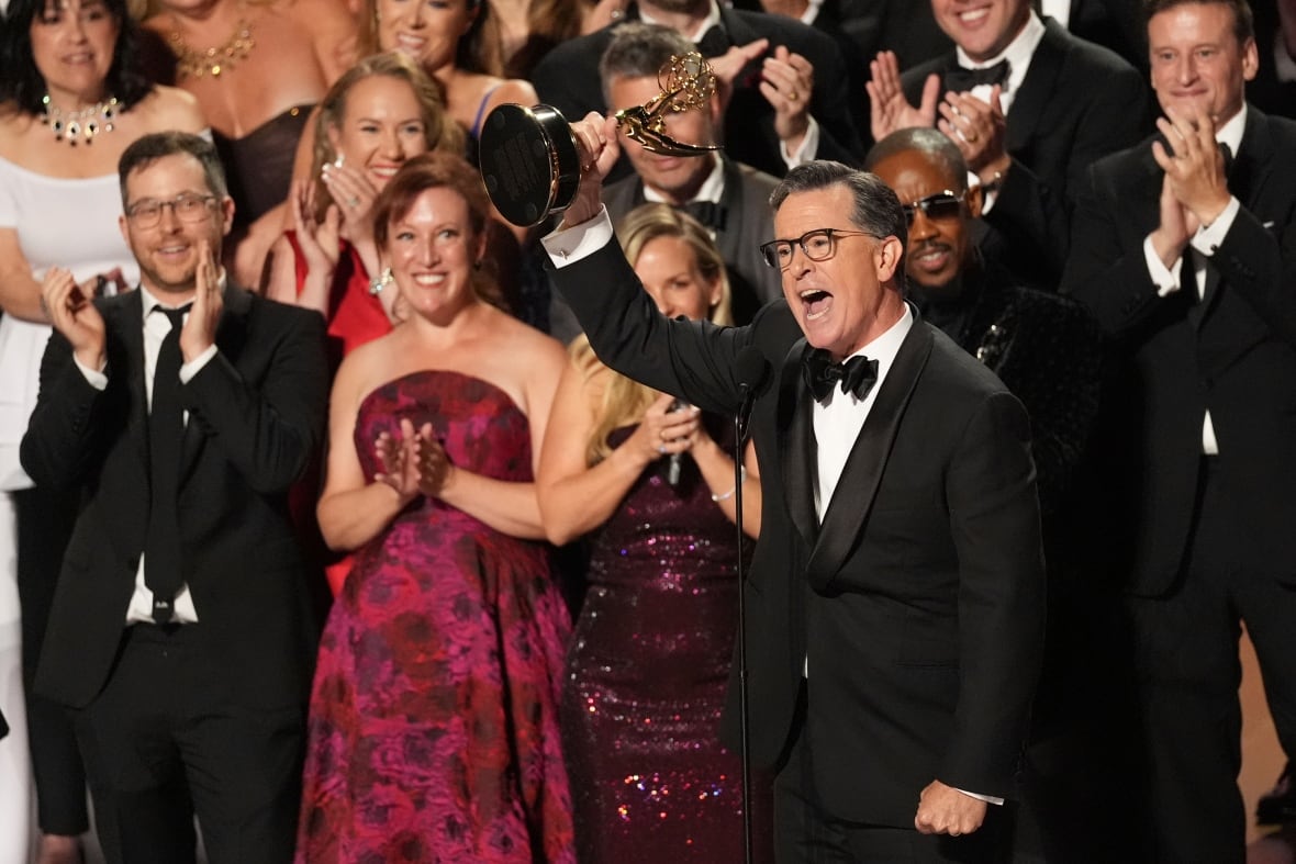 A man dressed in the crowd behind it lifts EMMY.