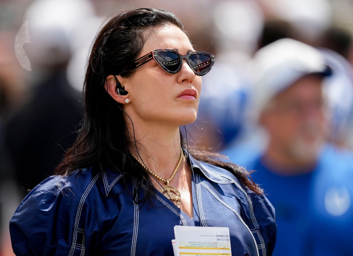 A woman in sunglasses looking towards a field