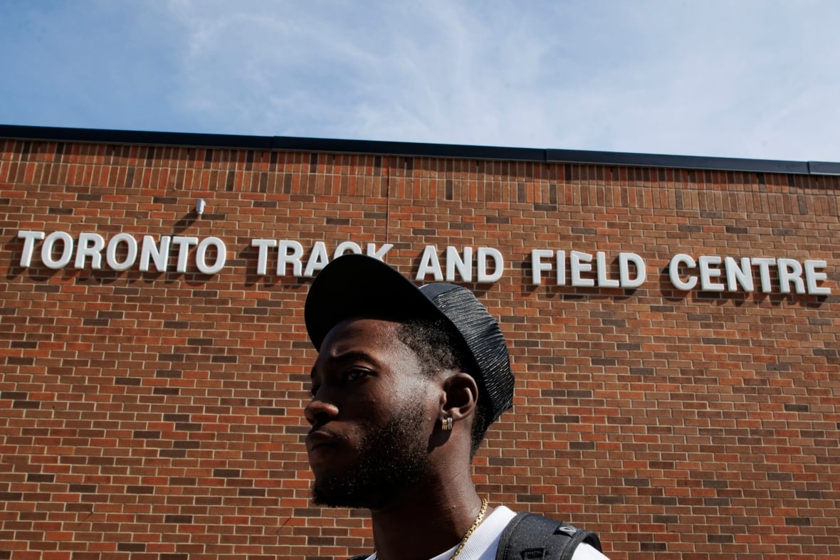 Man stands in front of "Toronto Track and Field Centre" sign