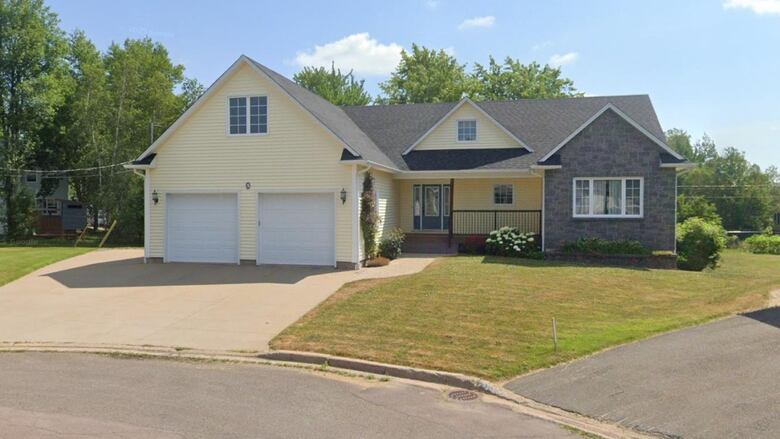 A yellow house with a double garage.