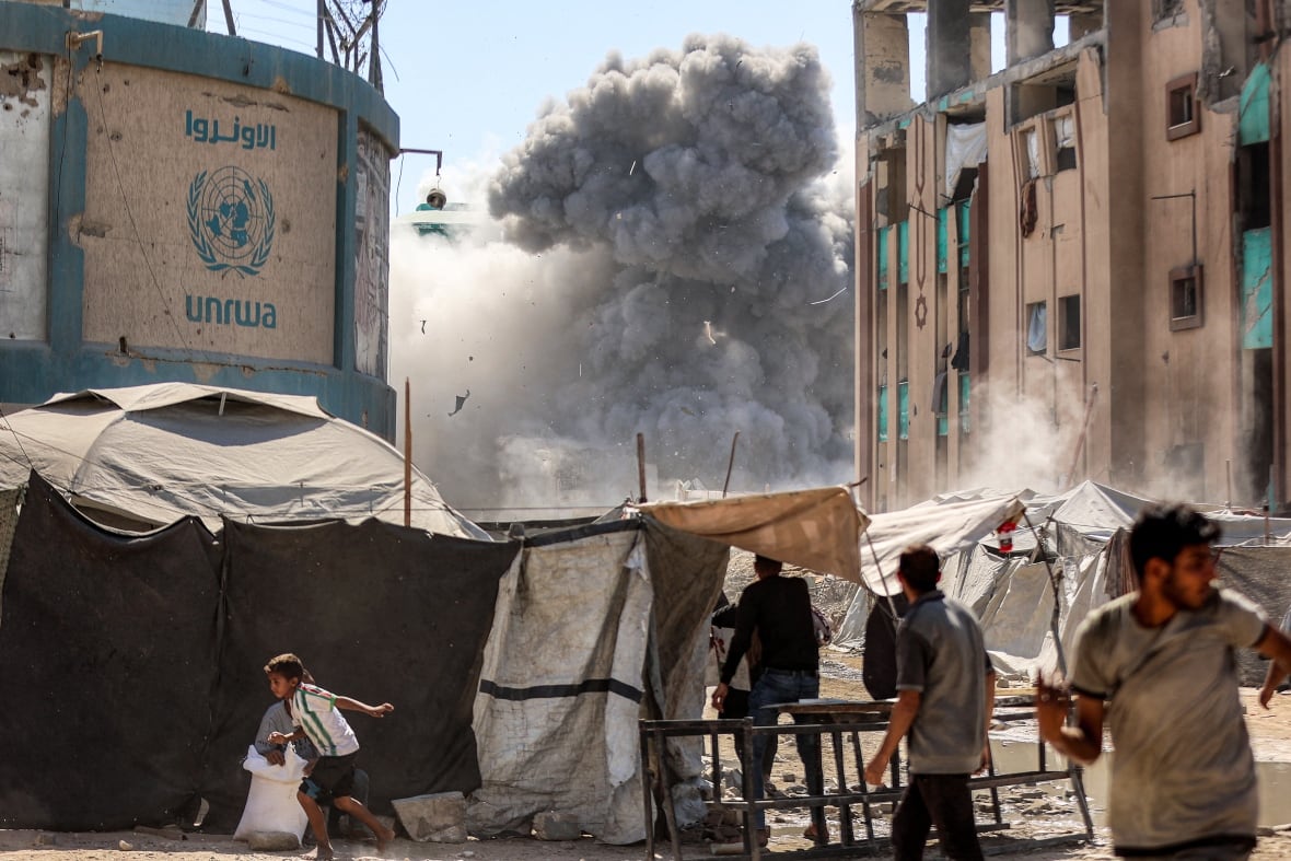 People run while smoke exploded from an explosion from a building.