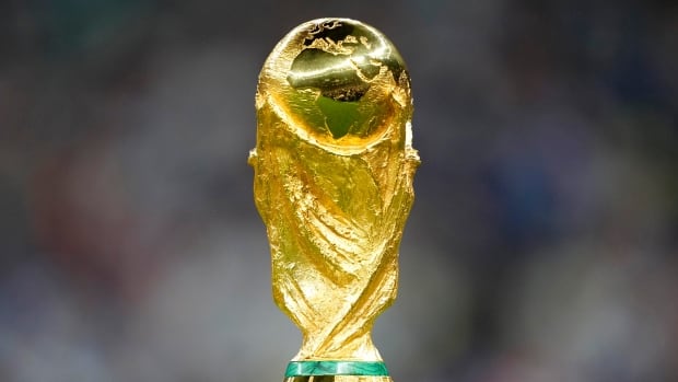 A gold trophy with two green horizontal lines at the bottom on display.