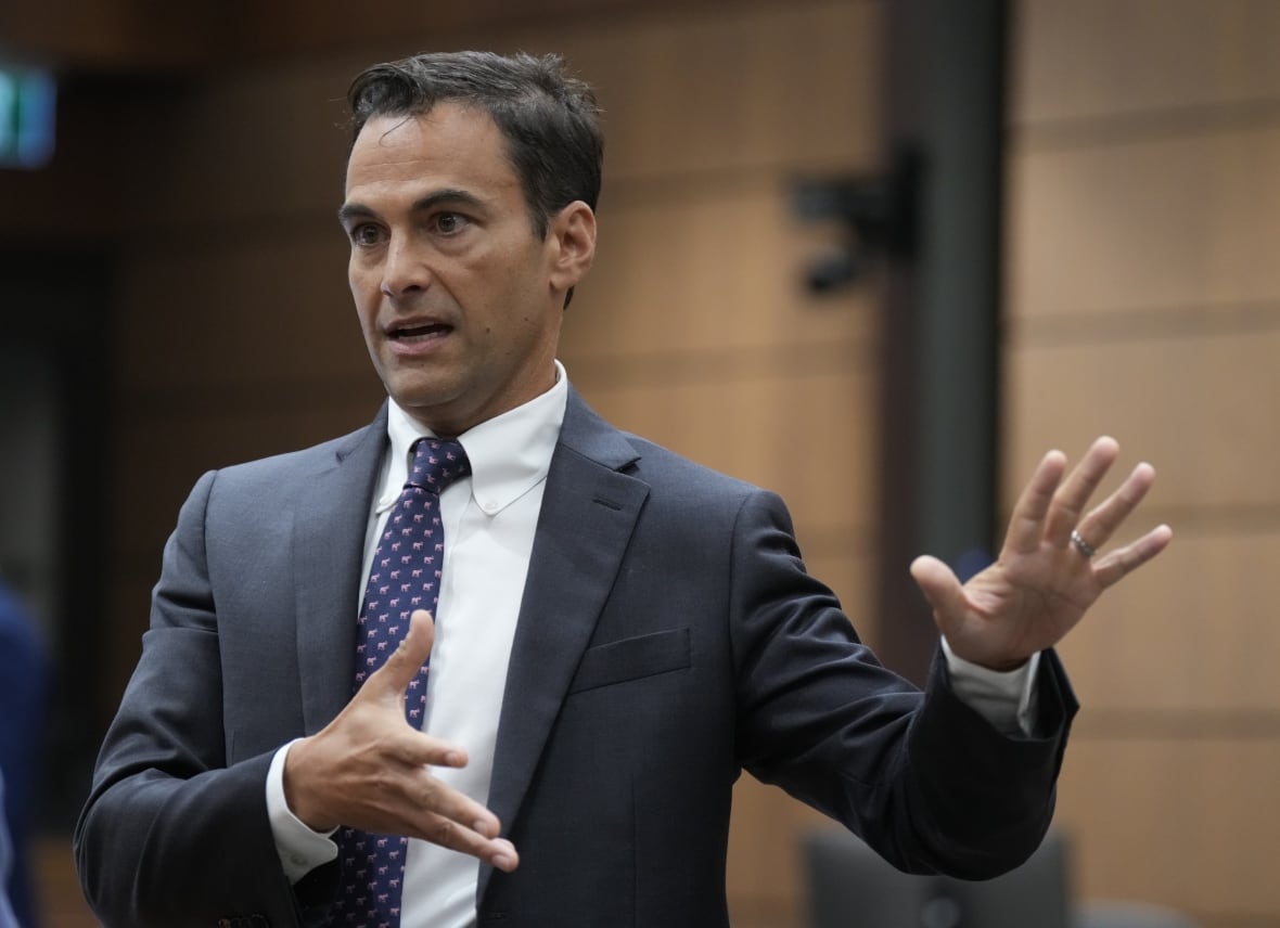 A man in a suit gestures