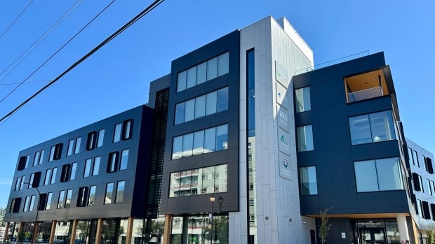 Photo shows a brand new five-storey building on a corner lot. 
