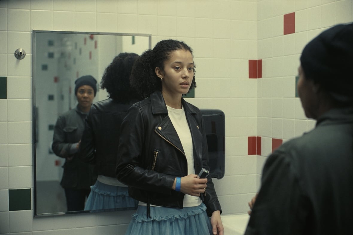 A teenager leaning against a sink is shown. 