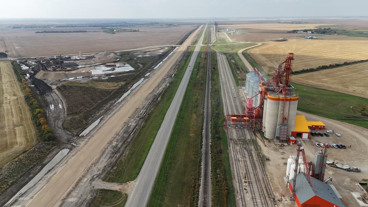 A photo taken by a drone shows an overhead view of a highway with a grain terminal beside it.