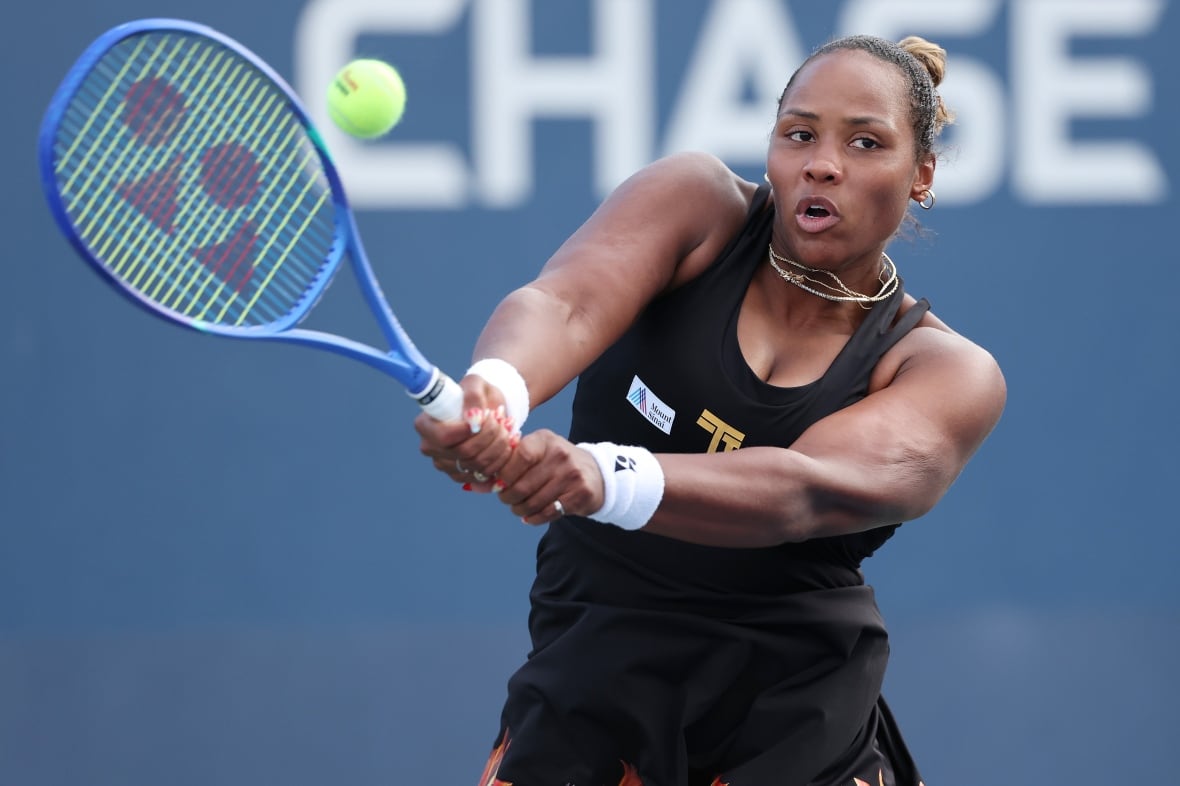 A woman in black tennis at work during the match.