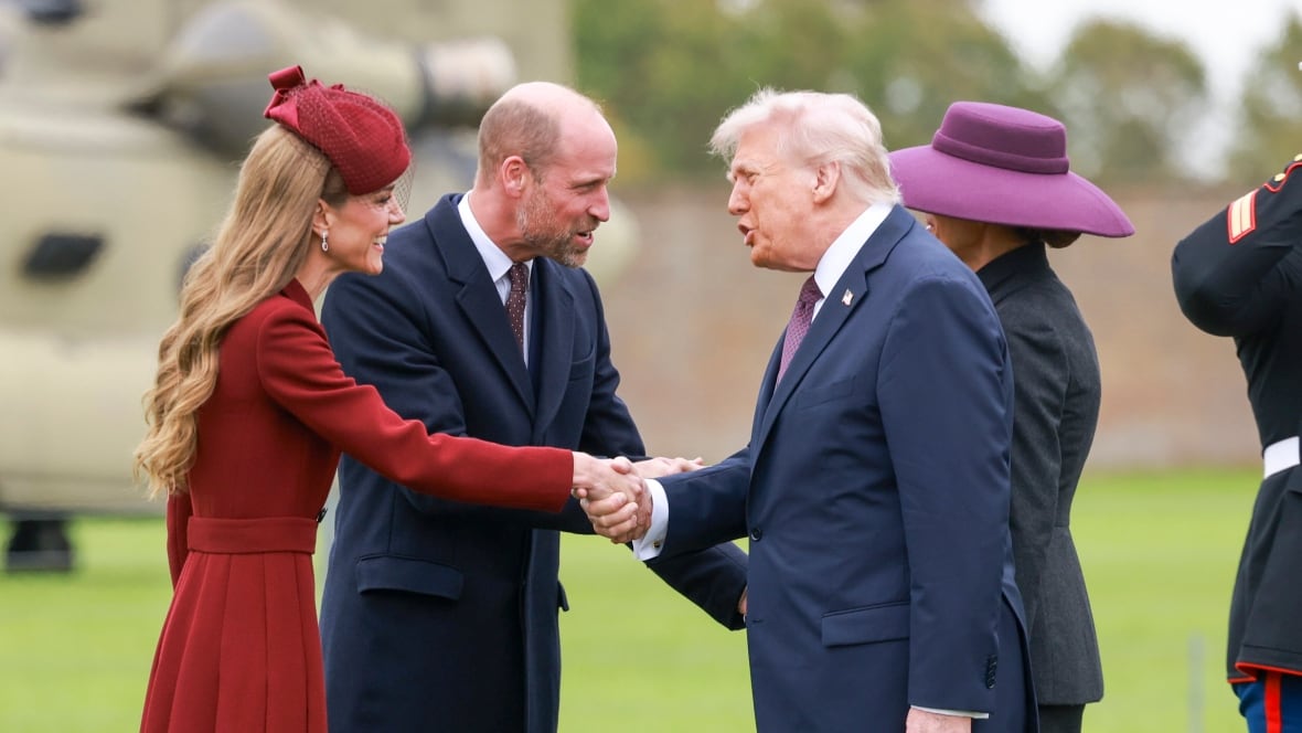 Four people in formal dress shake hands outside