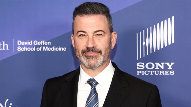 A medium shot showing television host Jimmy Kimmel posing for a photo.