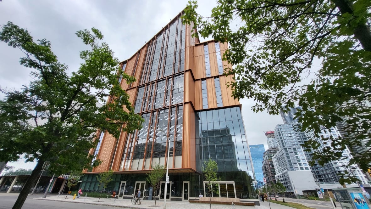 Exterior of a very tall glass and wood building