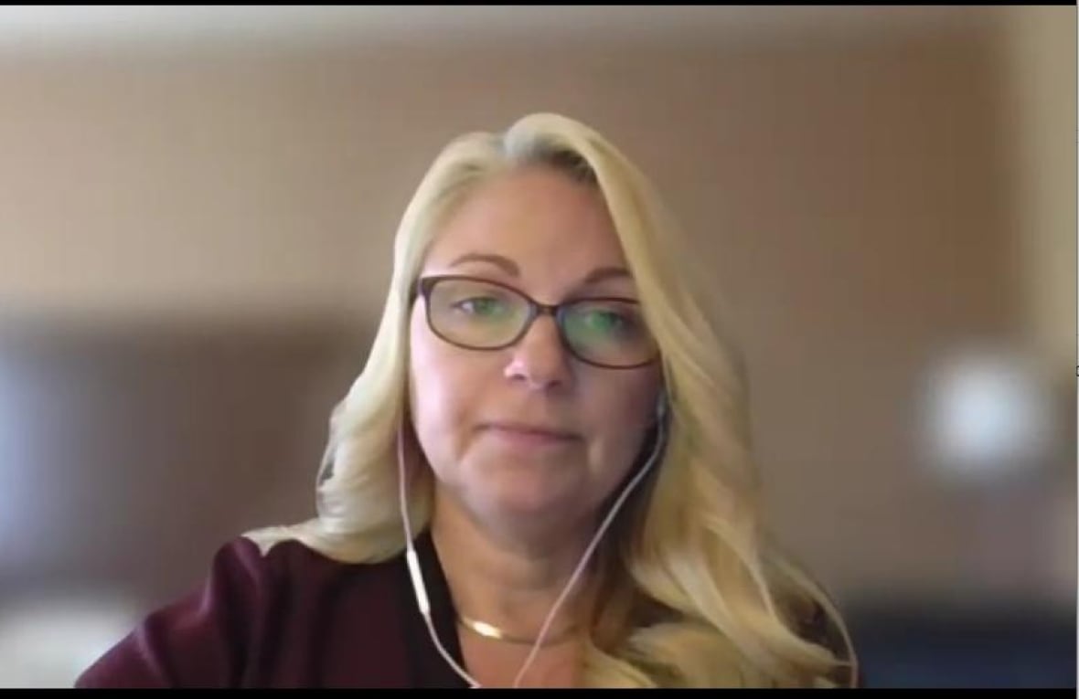 Woman looking at camera with a neutral expression in a video call.