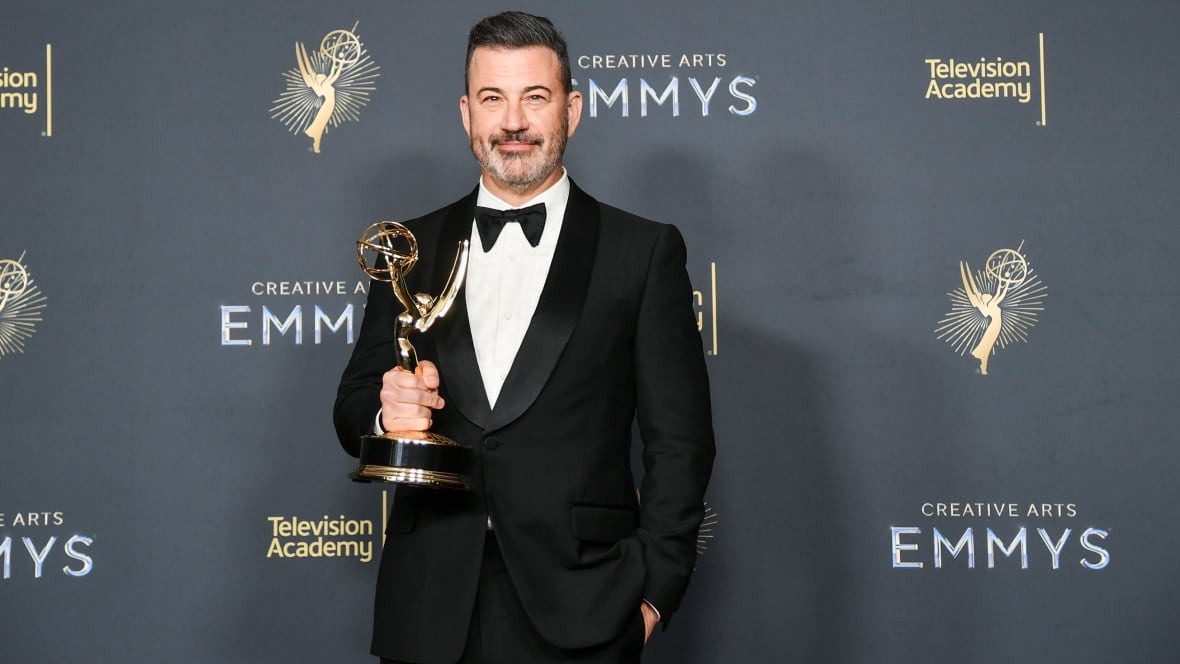 Jimmy Kimmel holding a Creative Arts Emmy Award trophy.