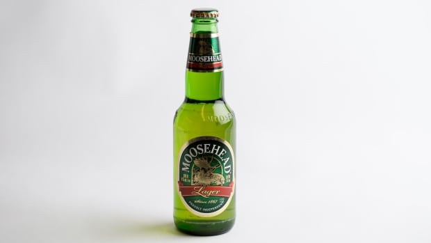 A green bottle of beer with a label featuring a moose and the words Moosehead Lager. 