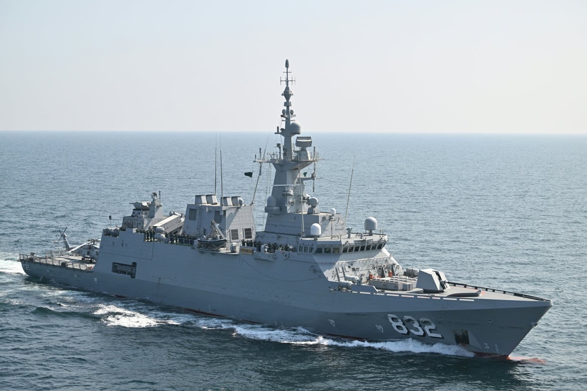 A large grey warship is shown in a body of water.