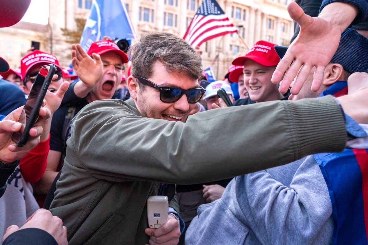 File- Nick Function Right-Wing Podcaster, Center, Callers Support Before Pro-Trump March, November 14, 2020, in Washington.