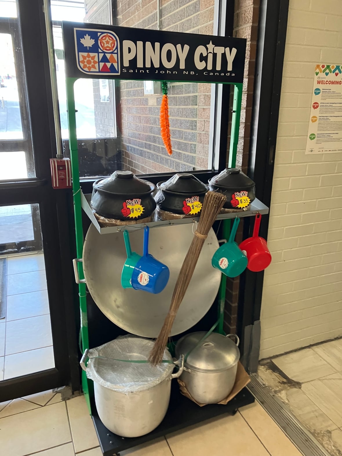 A shelf holding pots and pans beneath a sign reading "Pinoy City."