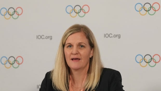 A woman speaks at a microphone.
