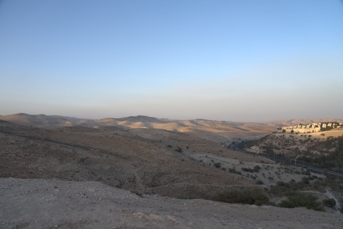 A wide shot of mountain desert landscapes under a clear blue sky.