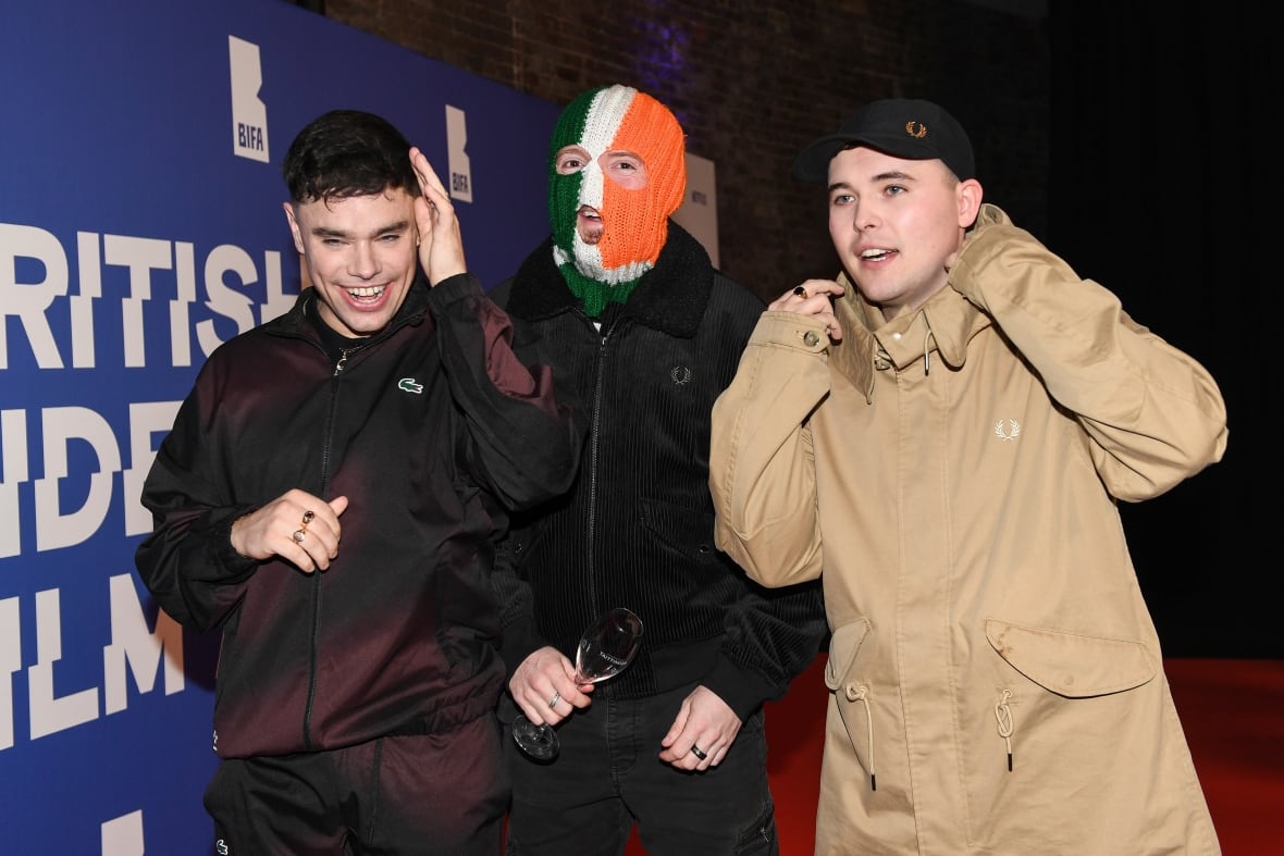 Three men pose at an award show.