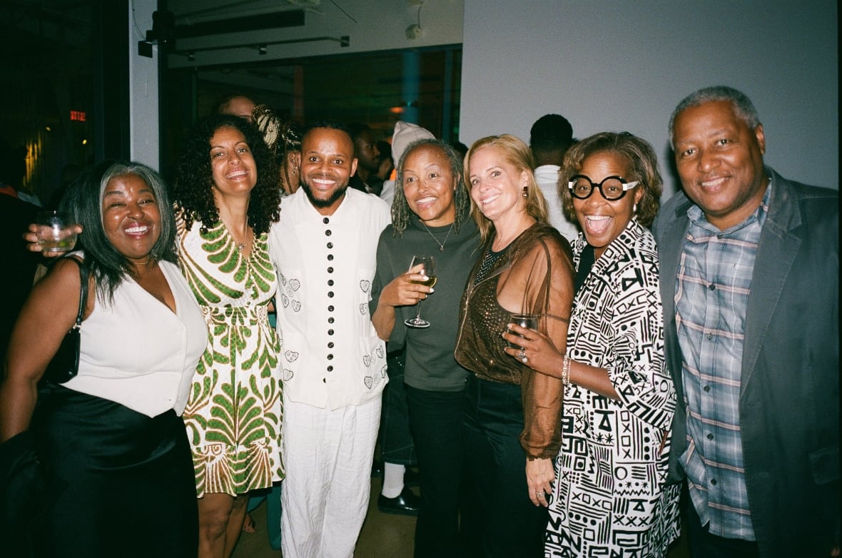 A group of seven people pose in a line for a photograph.