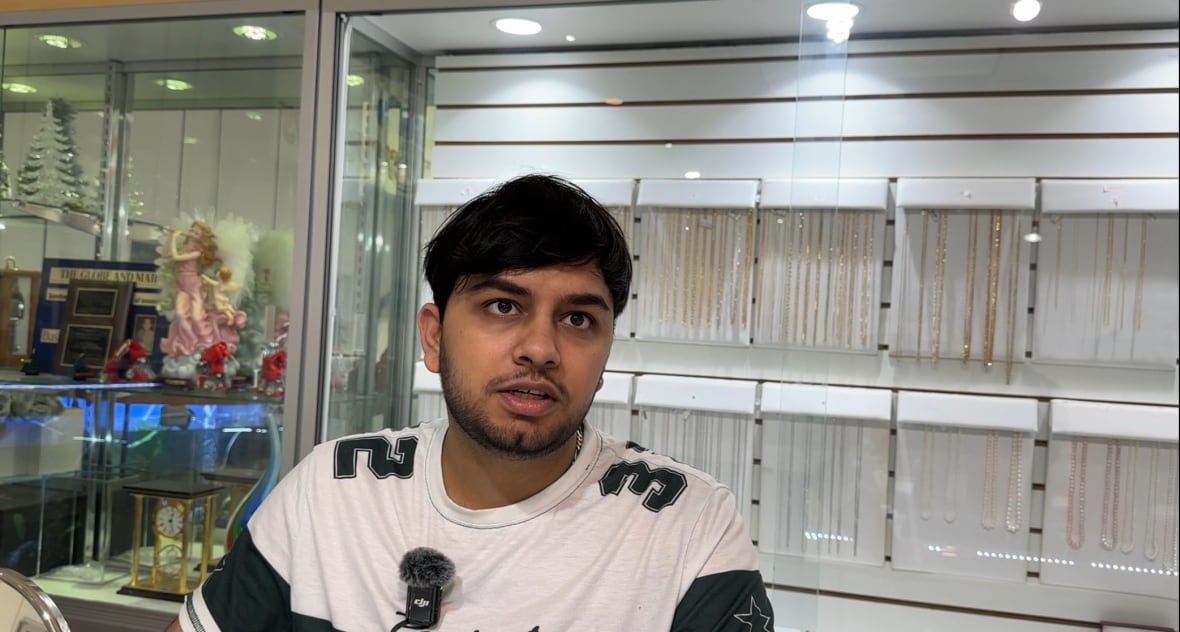 A man in a glass store stares ahead.