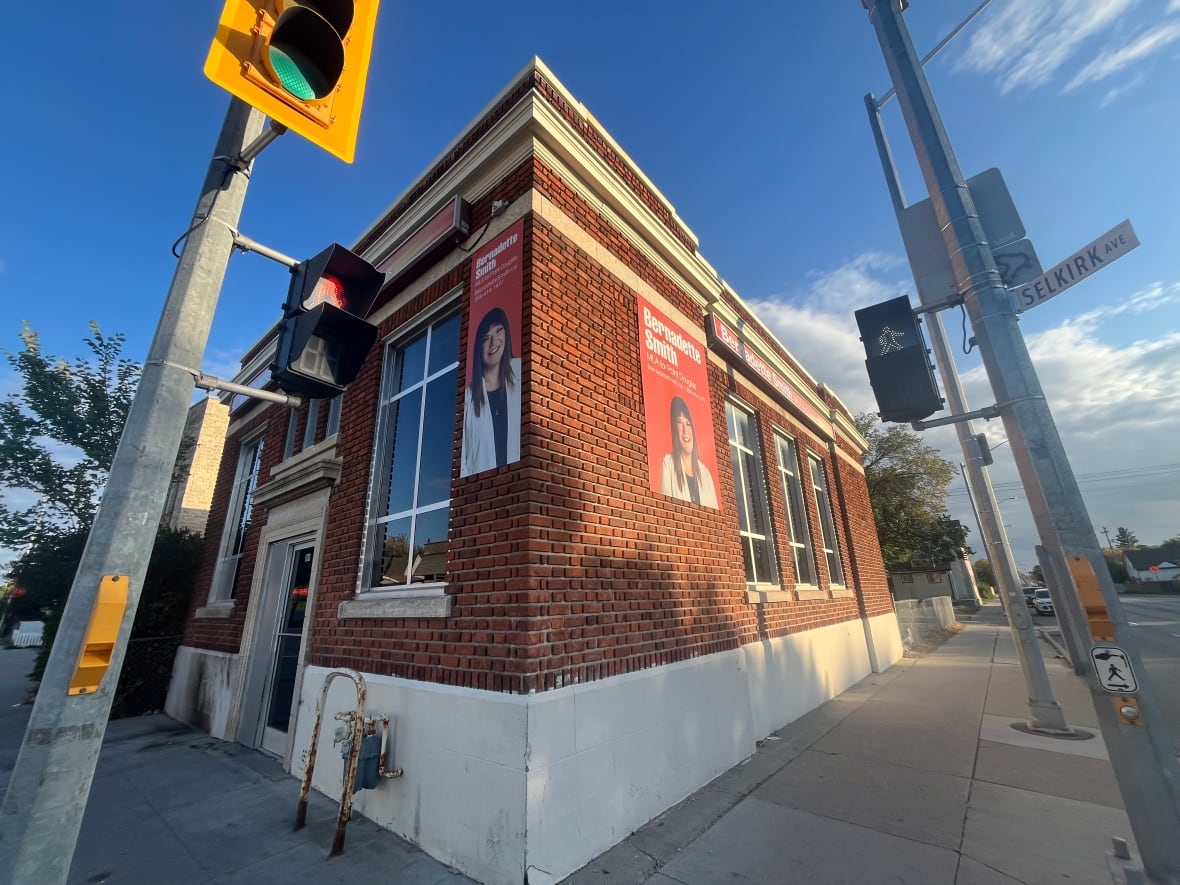 A brick building with posters bearing the image of Point Douglas MLA Bernadette Smith.