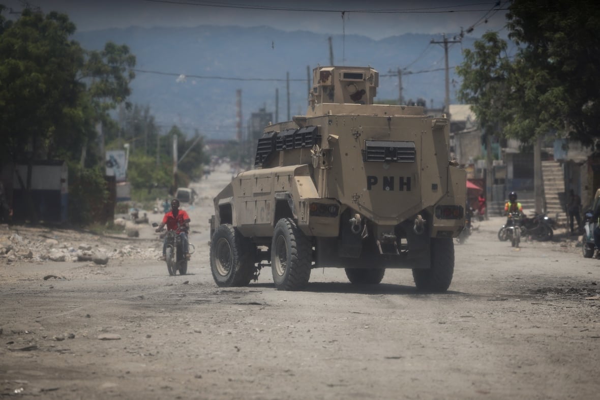The travel tank appears below a dirt road, with a man on a nearby bike. 
