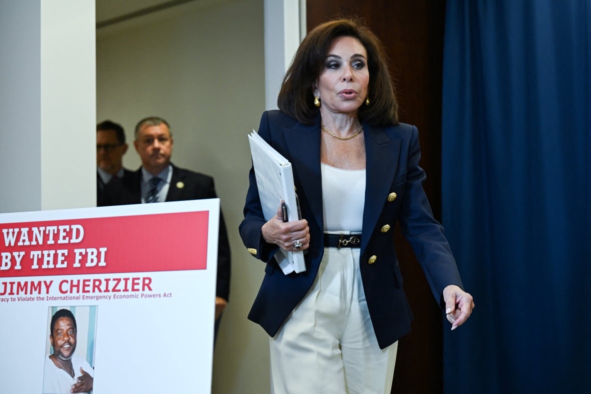 A woman appears in a barking jacket while walking in a room near a sign with a required sticker.