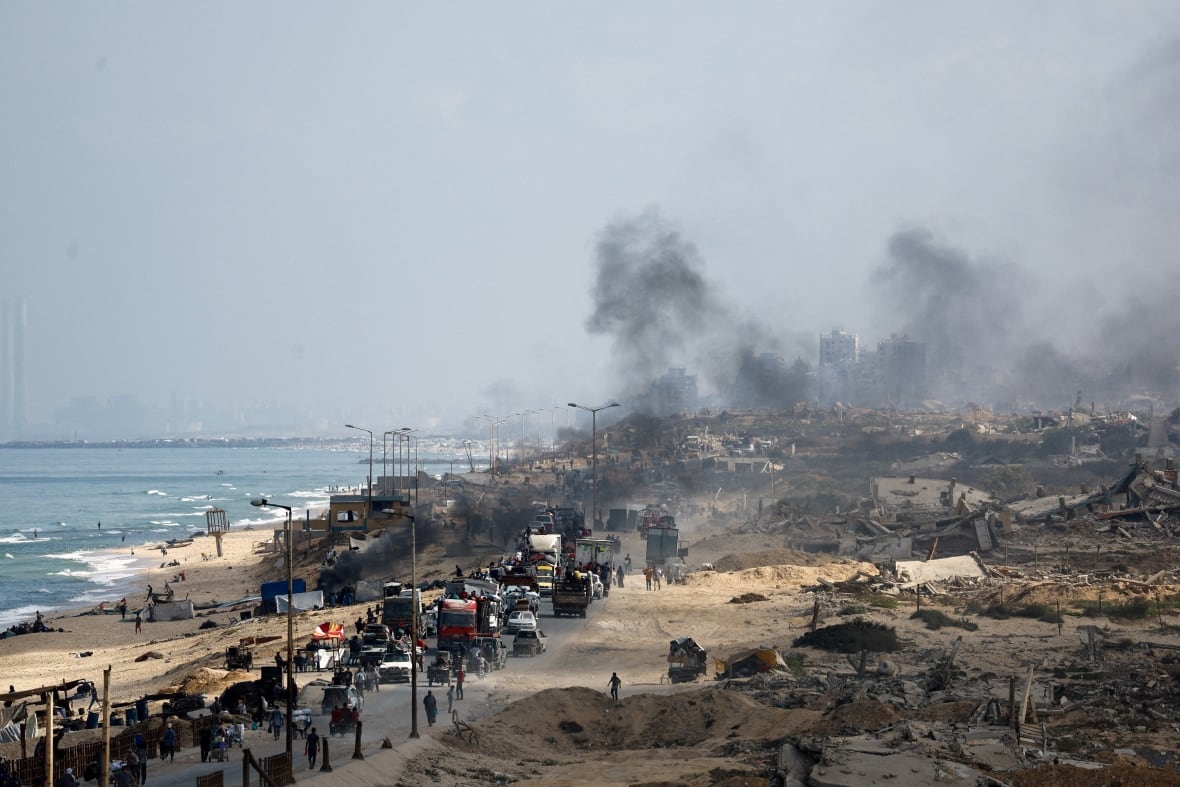 People move along a road in a devastating area.