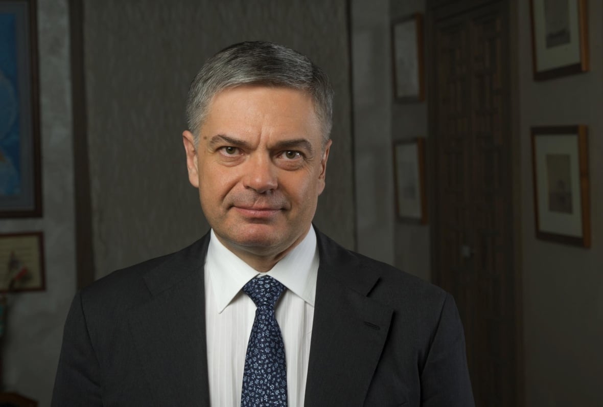 A man wearing a suit poses for the camera.