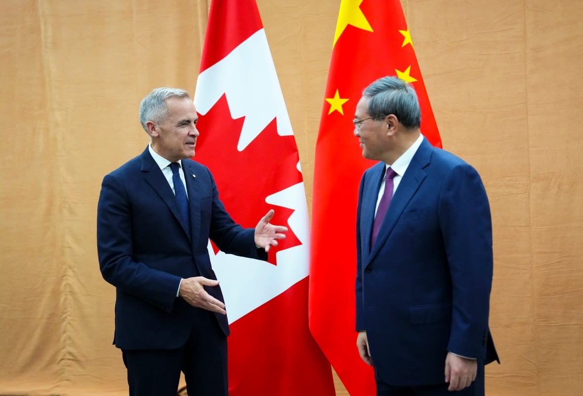 Twee mannen in pak spreken voor de Canadese en Chinese vlag.