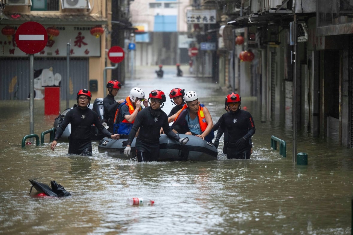 First responders wade through a water filled street.