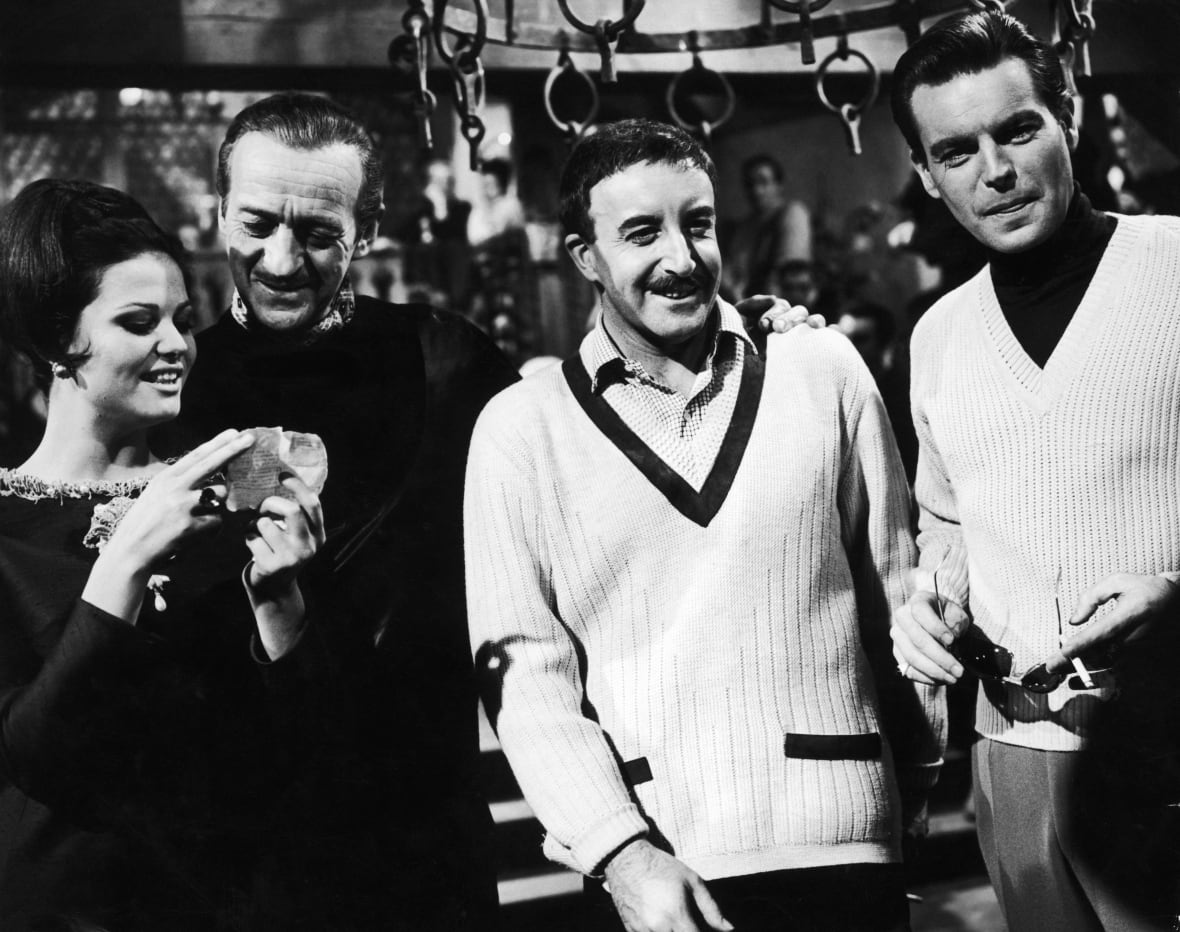 Una donna e tre uomini sono ritratti in una fotografia in bianco e nero che sembra vecchia di decenni.