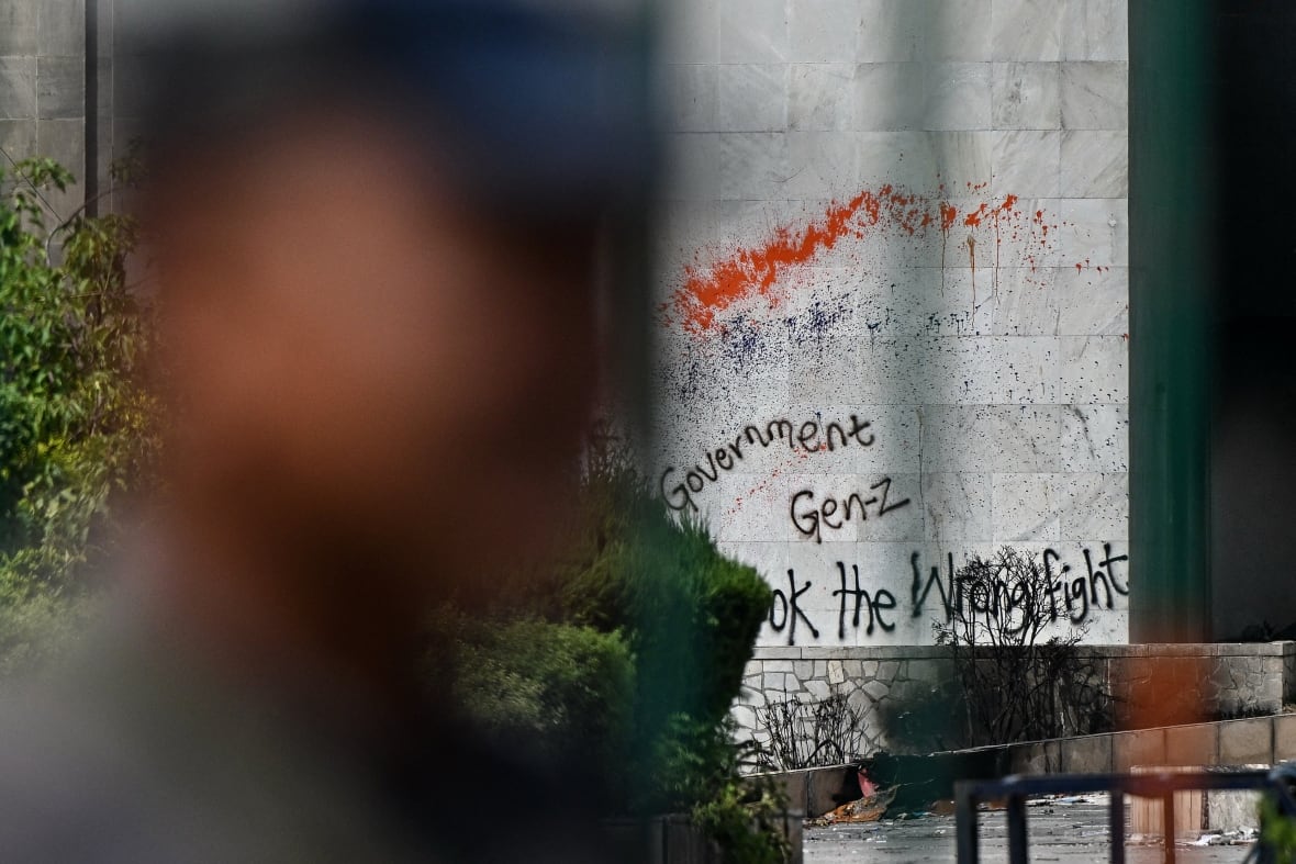 An unsatisfied profile of a man against writing on the walls was placed on a stone wall.