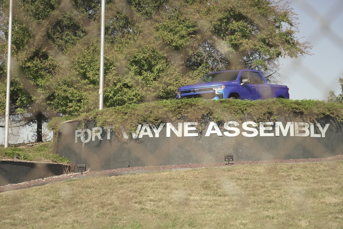 Photo showing a blue pick-up truck on a hill above a sign reading, Fort Wayne Assembly.