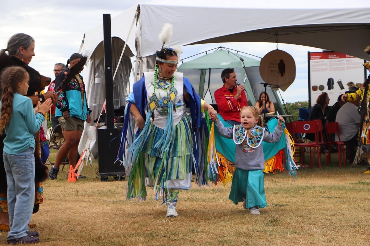 A woman dancing with a young girl. 