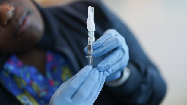 An immunization nurse holds a Pfizer-BioNTech COVID-19 vaccine in May 2025.