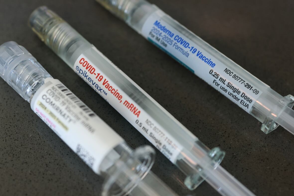 In this photo illustration,  Pfizer-BioNTech COVID-19 (L) and Moderna COVID-19 vaccines fill their syringes in May 2025 in Miami, Florida. 