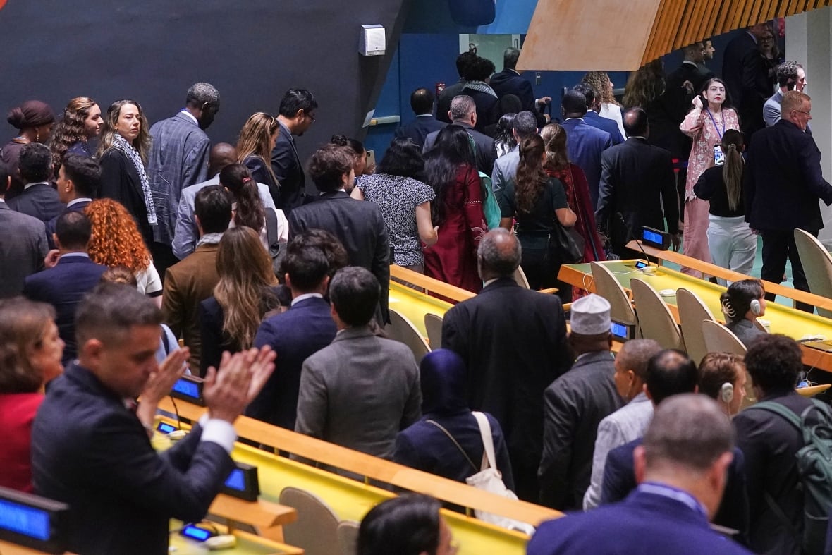 A group of people standing up will leave the room, back to chairs in the hall. 