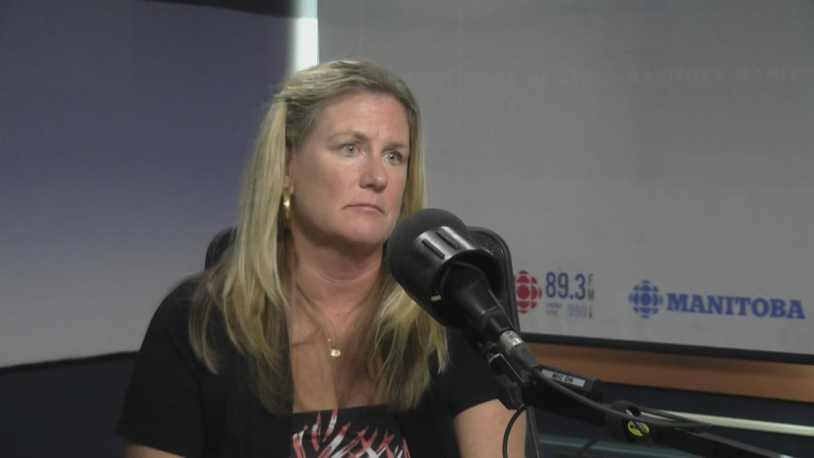 A blond-haired woman speaks into a microphone while sitting in a radio studio.