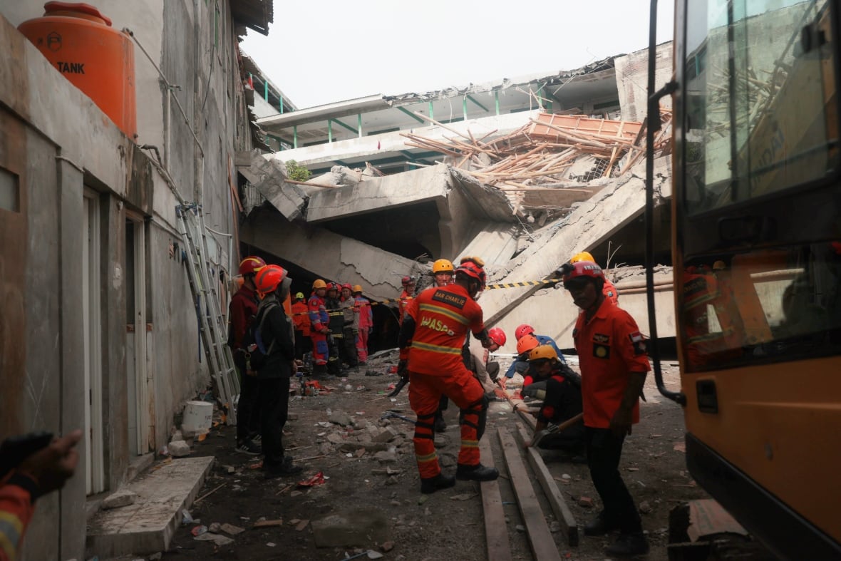 The Orange Coverls rescue workers work in the outsider of the building